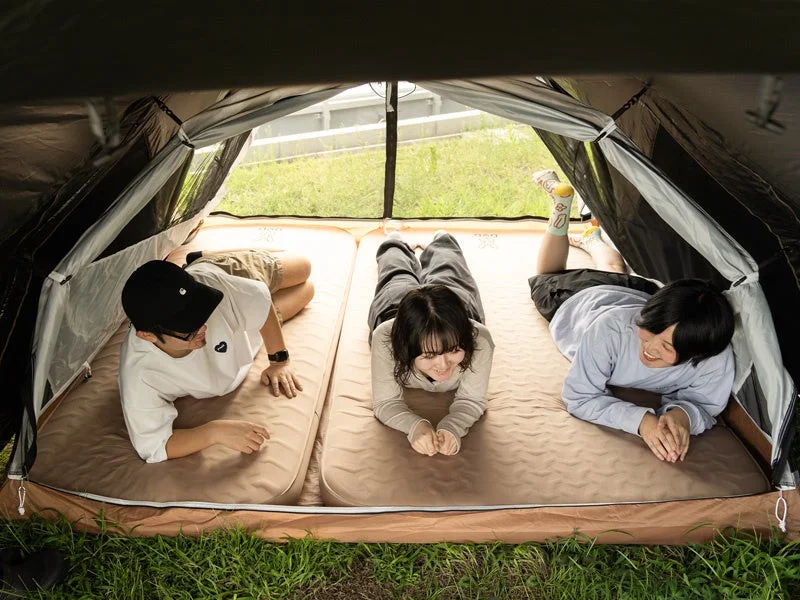 テントの中に3人の若者が寝転がっている様子
