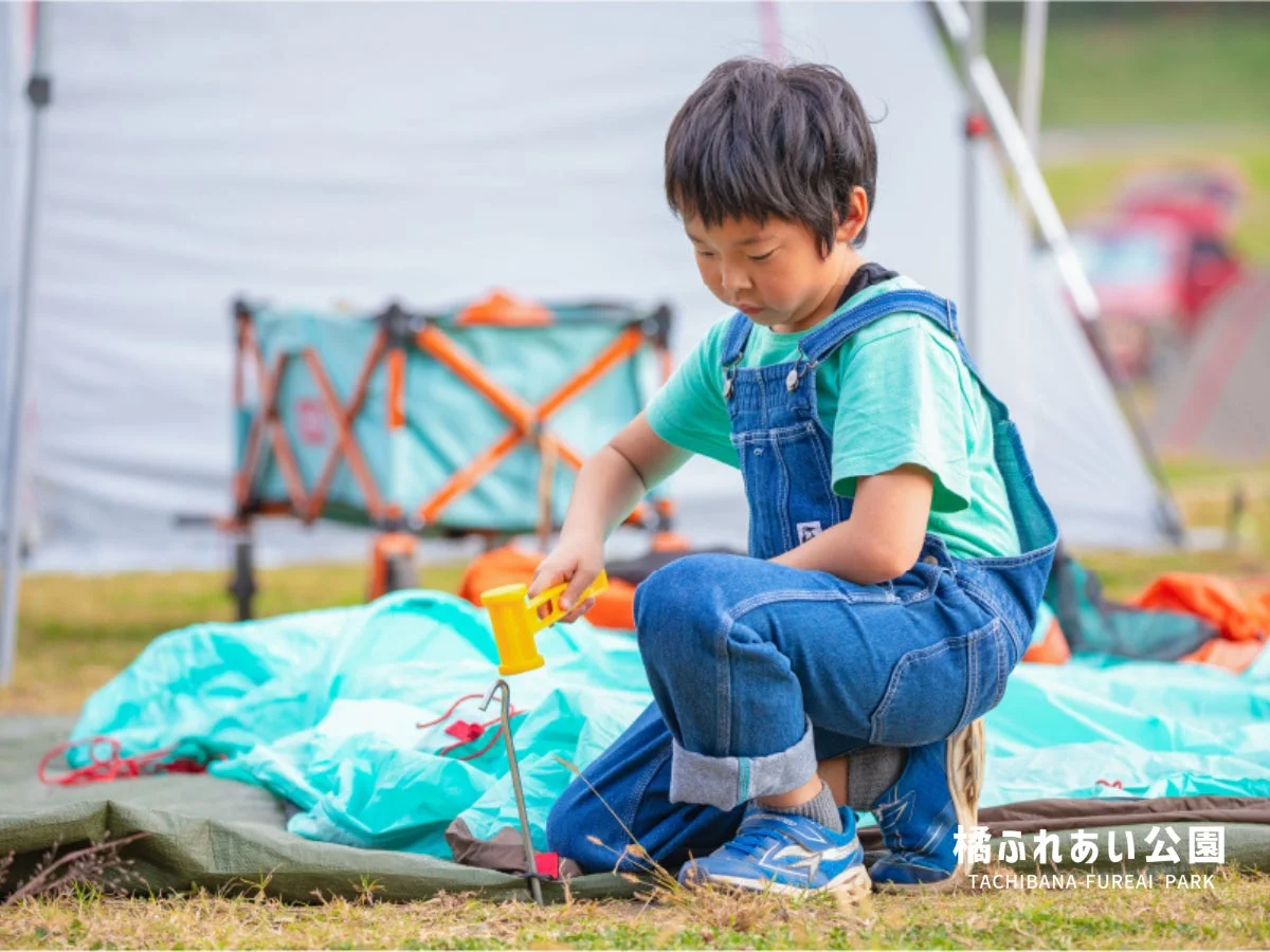 テント設営でペグを打つ男の子